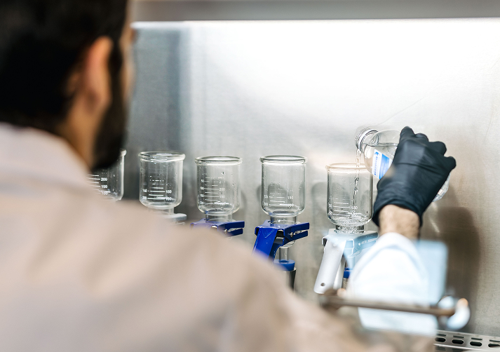 Personal de laboratorio de Cosaplag realizando la filtración de muestras de agua en una cabina de flujo laminar para el análisis preventivo y control de Legionella.